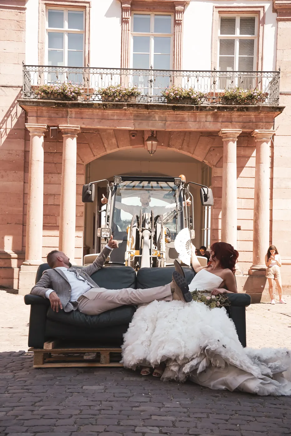 Les mariés installés sur un canapé porté par un chariot télescopique devant l'hôtel de ville