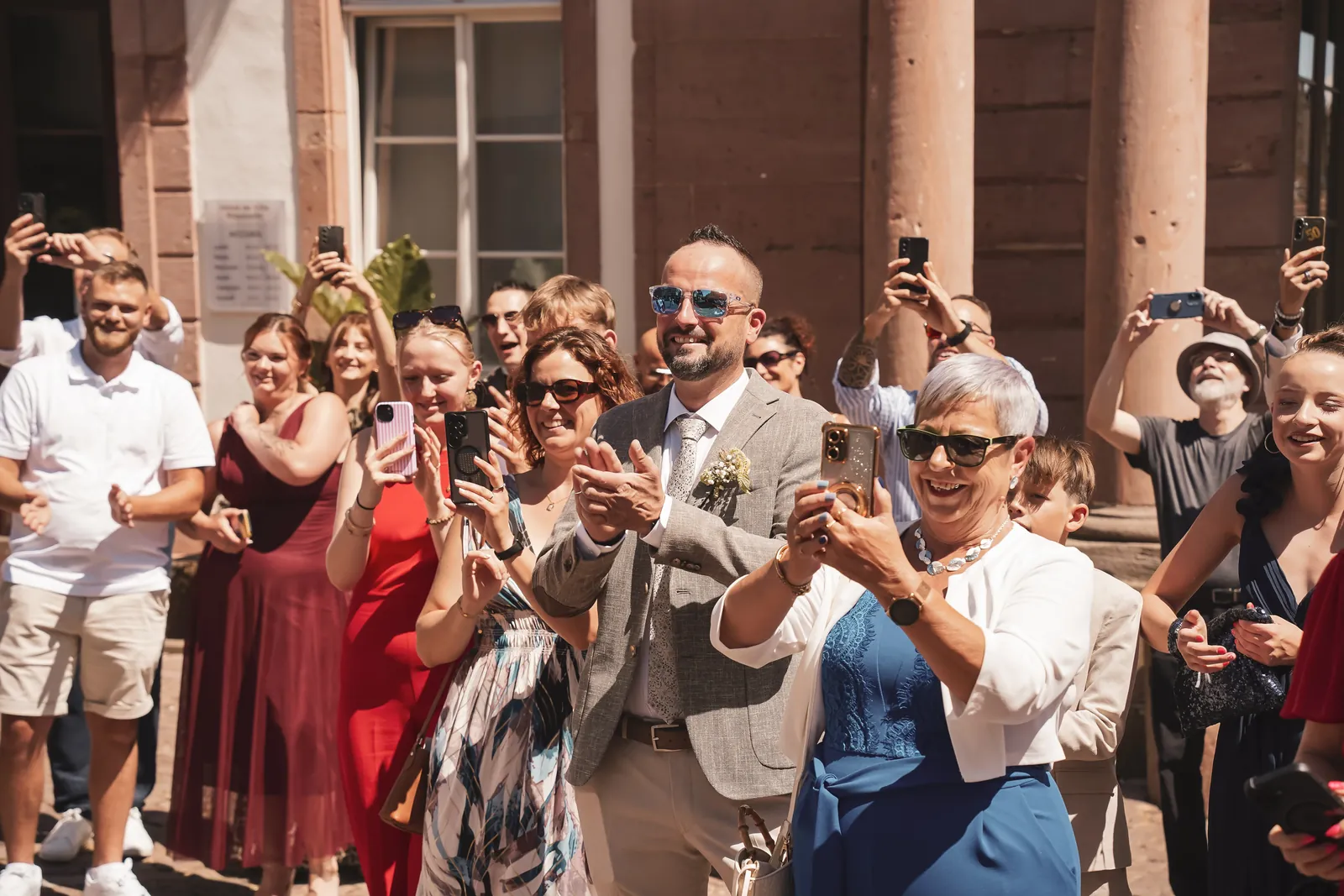 Les invités applaudissent les mariés à la sortie de la mairie