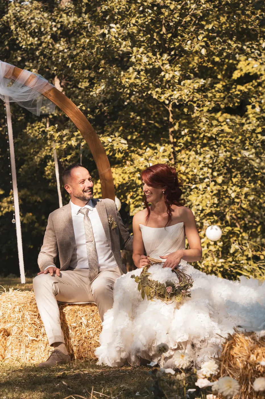 Charlotte et Bruno assis sur des bottes de paille pendant leur cérémonie laïque